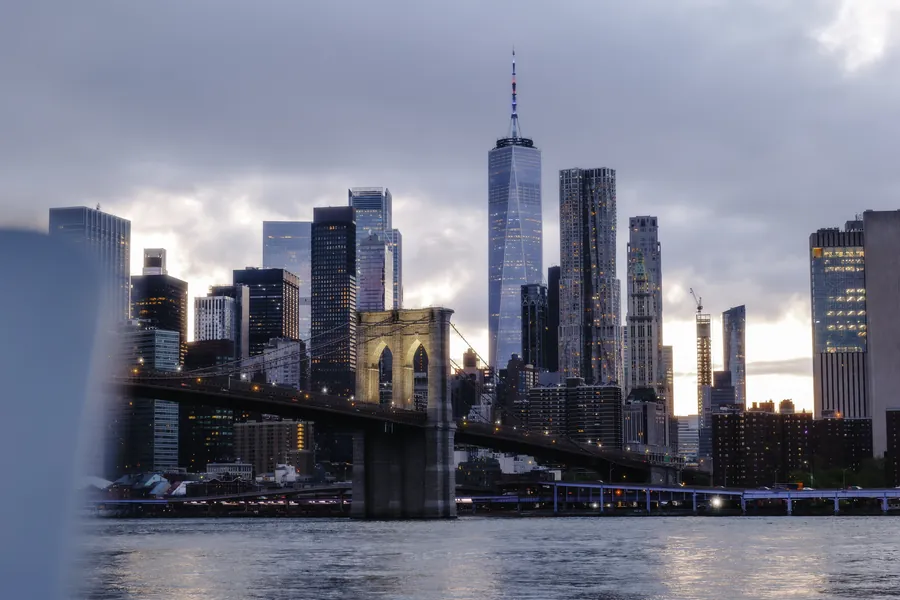 The Lower Manhattan skyline and the Brooklyn Bridge at blue hour.